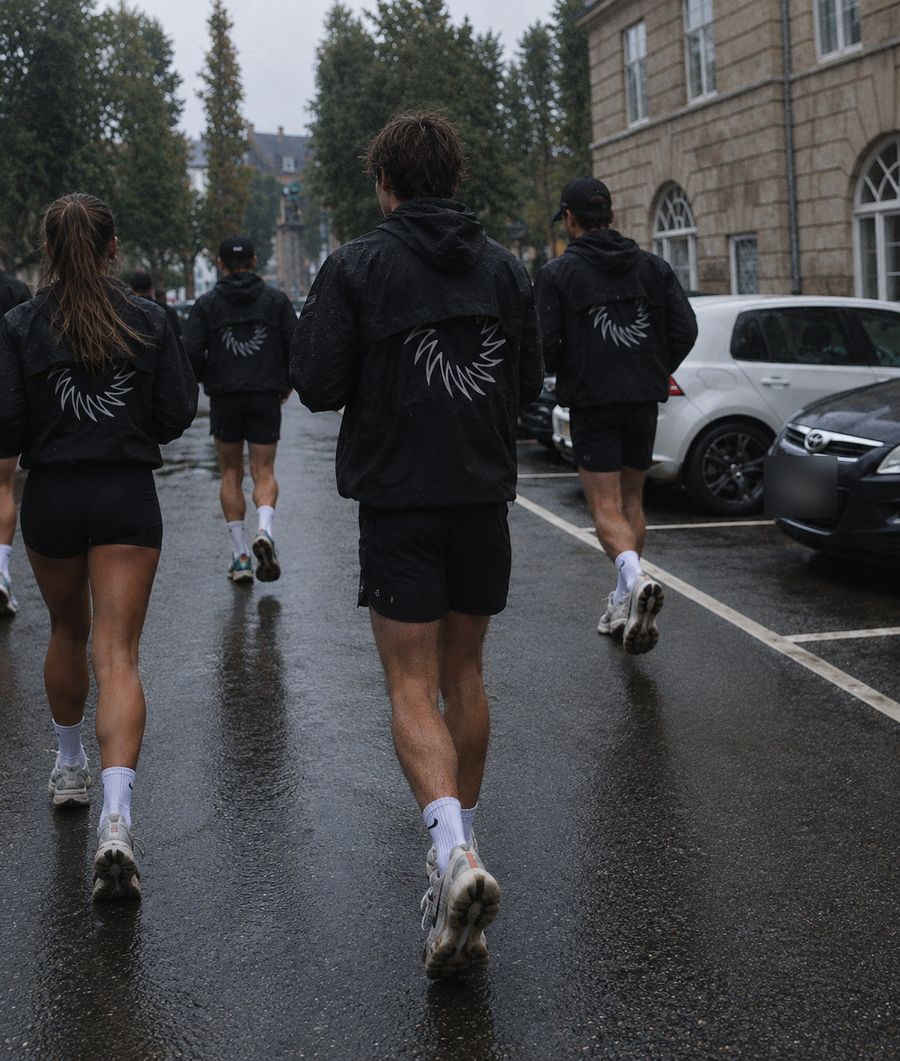 Runners walk through a wet street in the rain